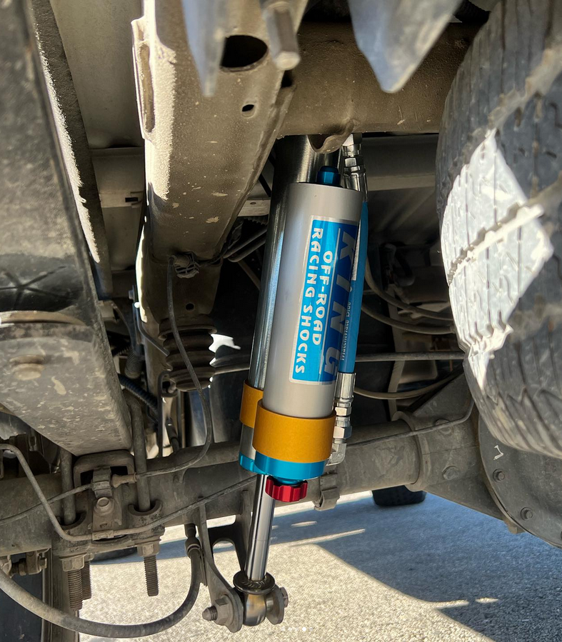 A shock on the back of a truck that says off road racing shocks