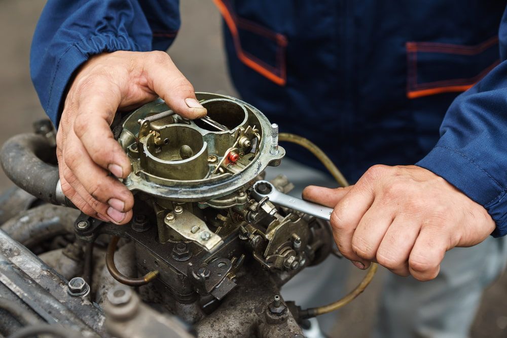 A Man Is Working On A Car Engine With A Wrench — Tonics Automotive in Bohle Plains, QLD