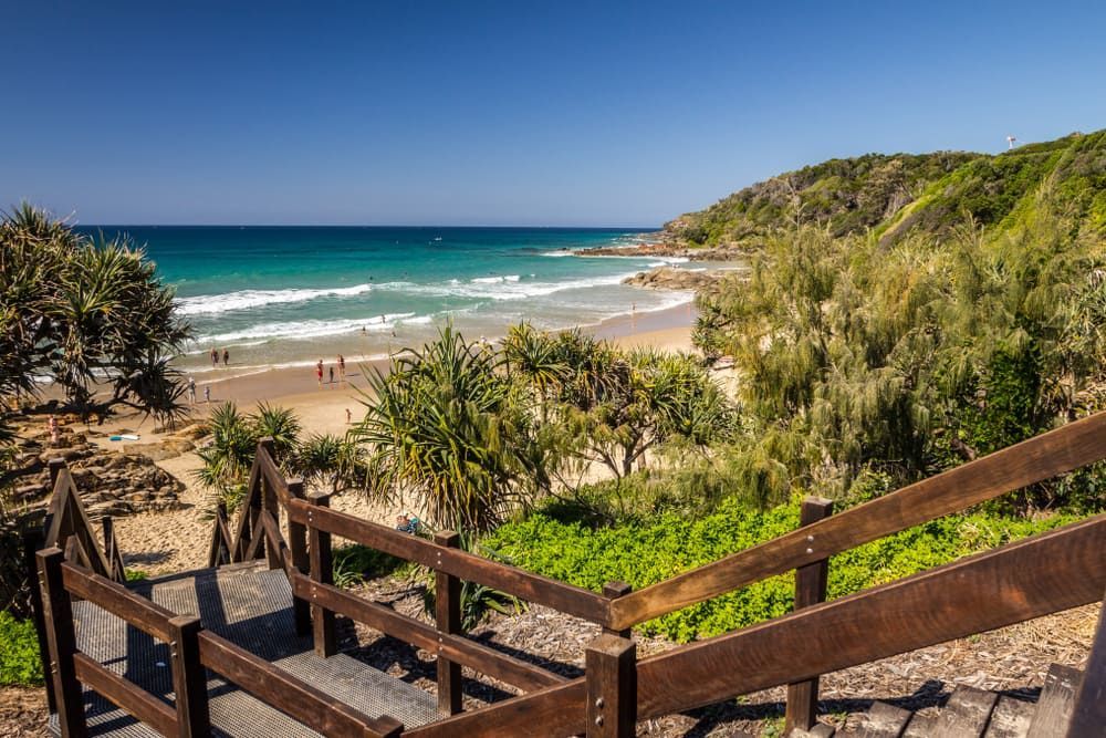 A Wooden Staircase Leading Up To A Beach With A View Of The Ocean — Tonics Automotive in Douglas, QLD