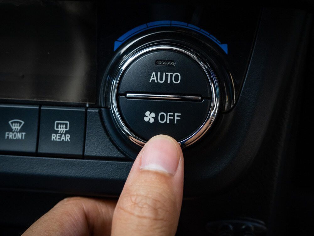 A Person Is Pressing A Button On A Car Air Conditioning System — Tonics Automotive in Garbutt, QLD