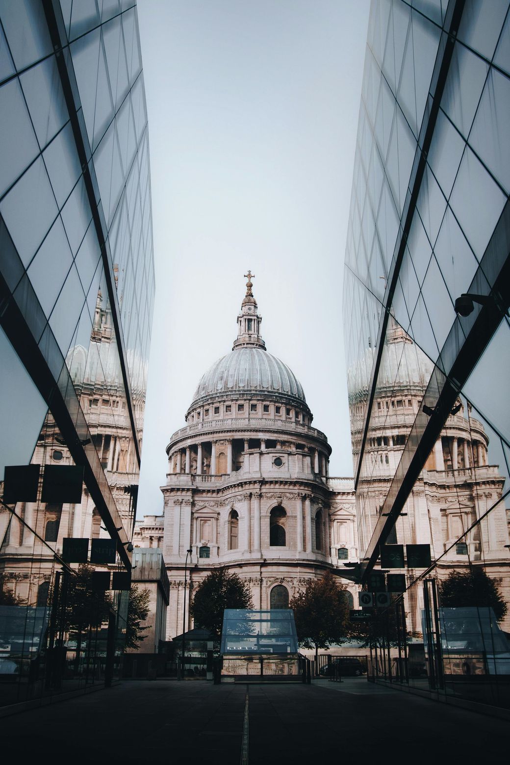 A large building with a dome is between two tall buildings.