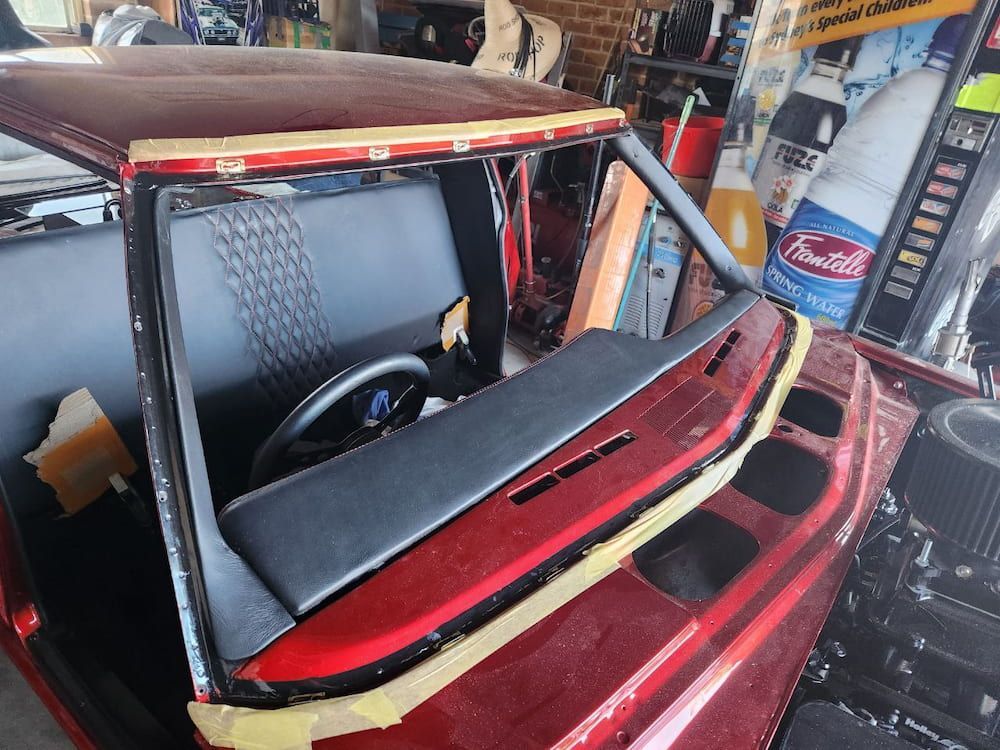 A Red Car is Being Worked on in a Garage — MJR Auto Glass In Canberra, ACT