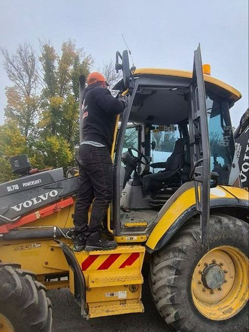 A Man Is Getting Out Of A Yellow Volvo Tractor — MJR Auto Glass In Goulburn, NSW