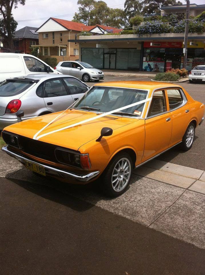 A Yellow Car With White Ribbon On The Windshield Is Parked On The Side Of The Road — MJR Auto Glass In Goulburn, NSW