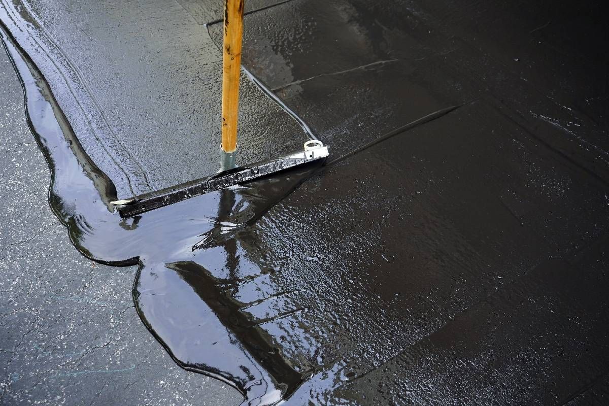 Someone using a squeegee to complete an asphalt seal coating near Richmond, Kentucky (KY)