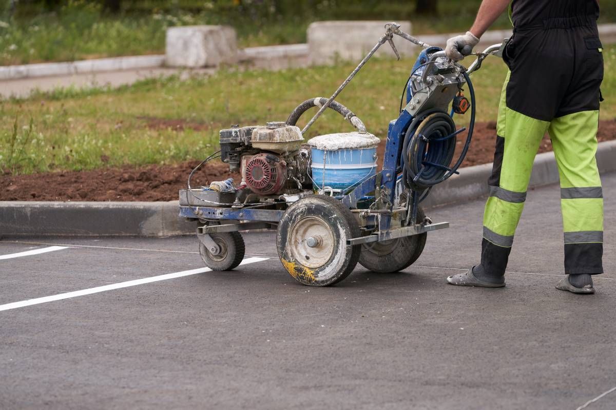 Someone using a machine to paint lines in a parking lot at Tates Creek Paving near Lexington, Kentucky (KY)