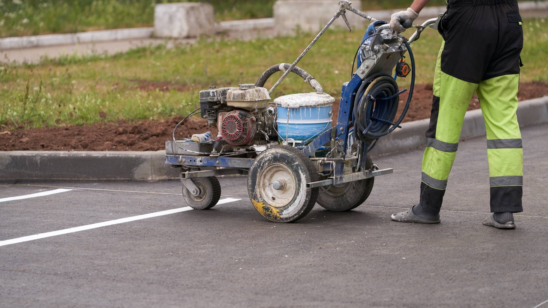 Someone using a machine to paint lines in a parking lot at Tates Creek Paving near Lexington, Kentuc