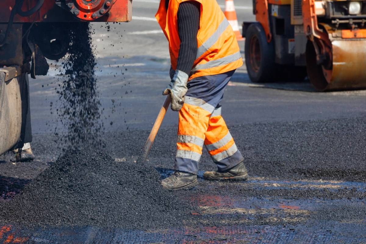 Someone shoveling fresh asphalt as part of paving services at Tates Creek Paving near Lexington, Kentucky (KY)