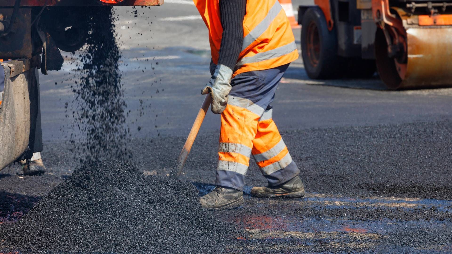 Someone shoveling fresh asphalt as part of paving services at Tates Creek Paving near Lexington, Ken