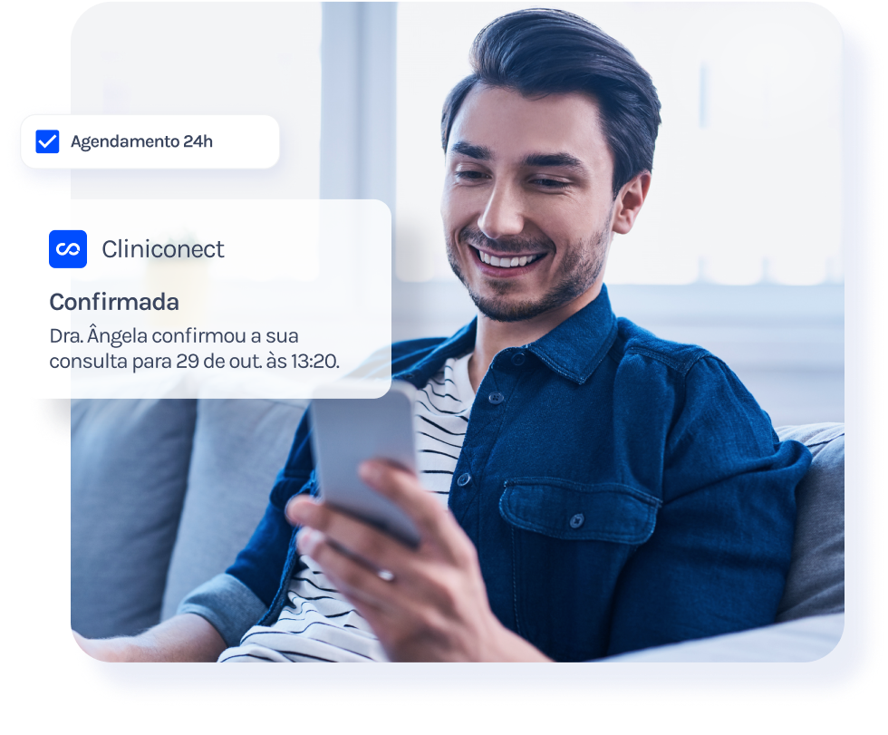 Um homem está sentado no sofá olhando para o celular.