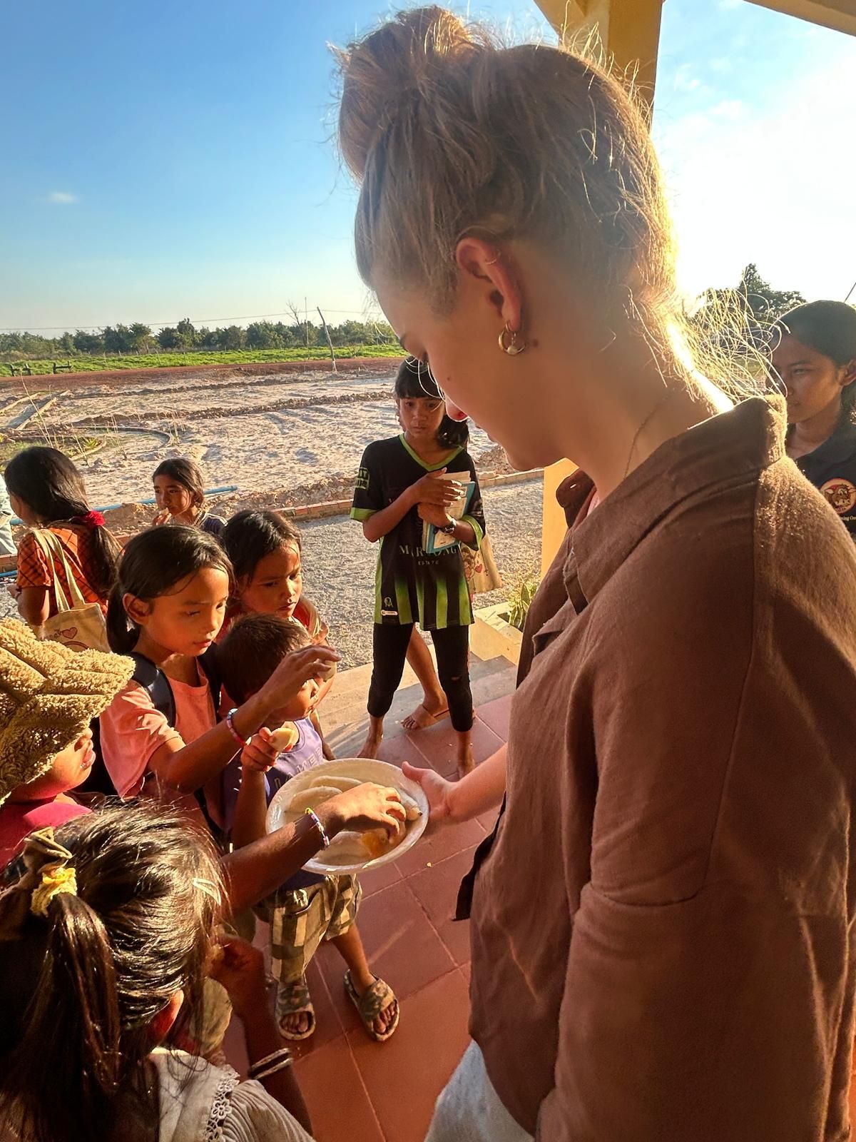 Family selfie at sunset; sky orange and blue, four smiling people on a road.