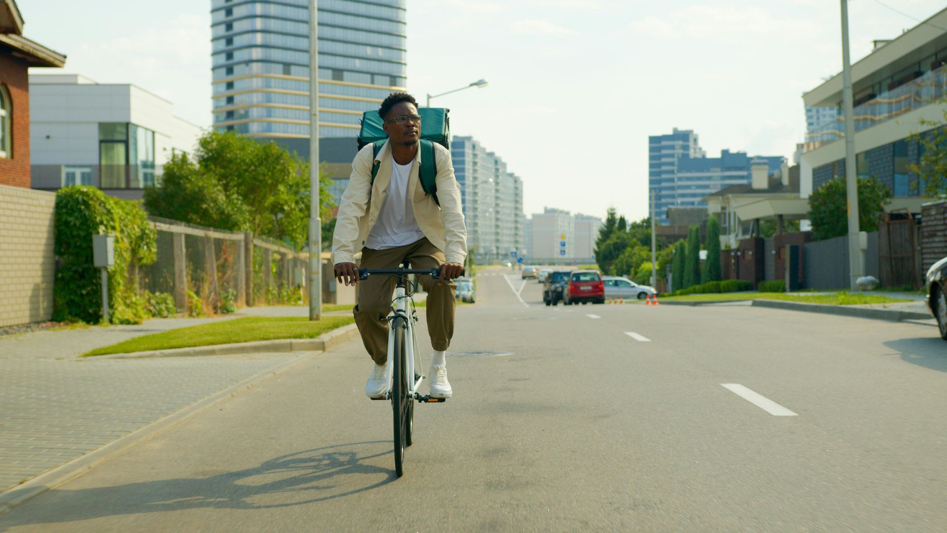 A man is riding a bike down a city street.