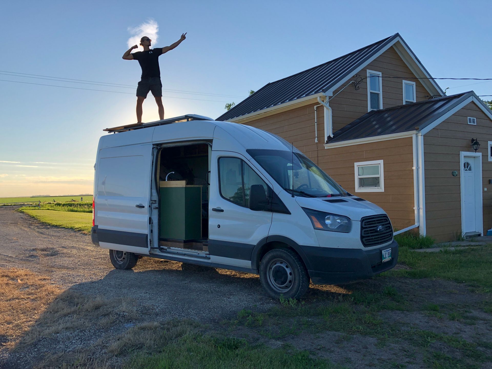 Justin Craddock posing on top of his converted campervan, as the coolest guy in Winnipeg