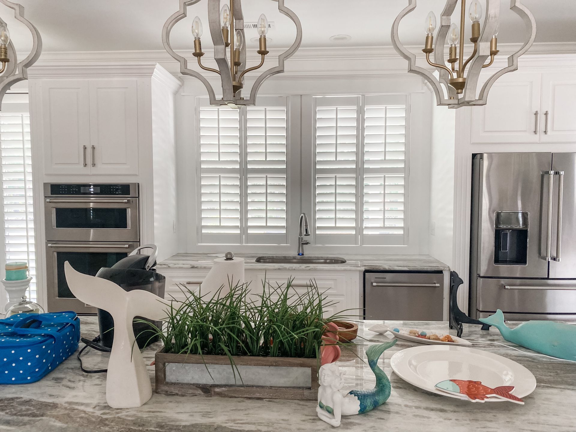 White kitchen with countertops, appliances, and decorative items.