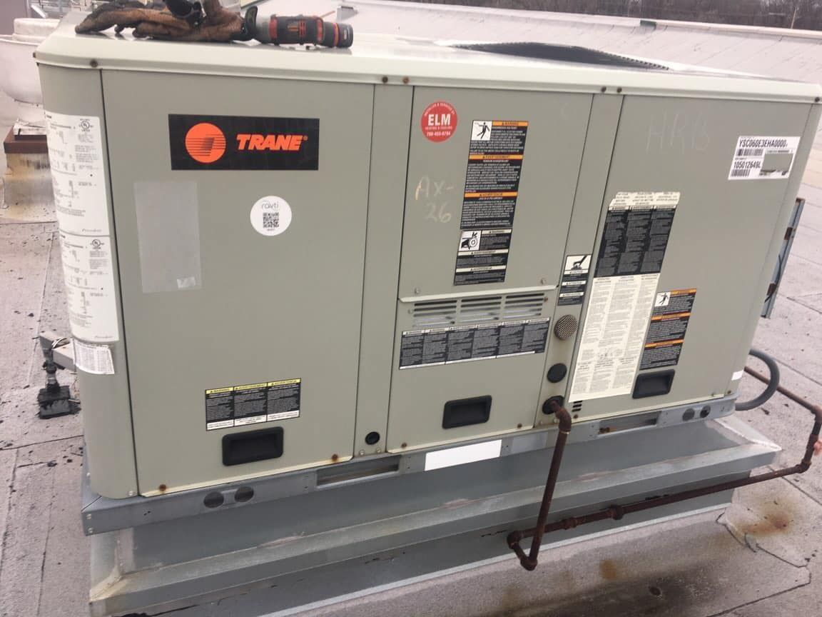 A trane air conditioner is sitting on top of a roof.