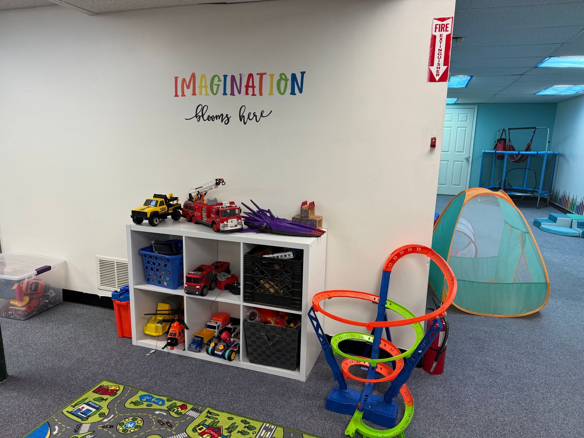 A Little Girl is Sitting at a Table Playing With Wooden Blocks