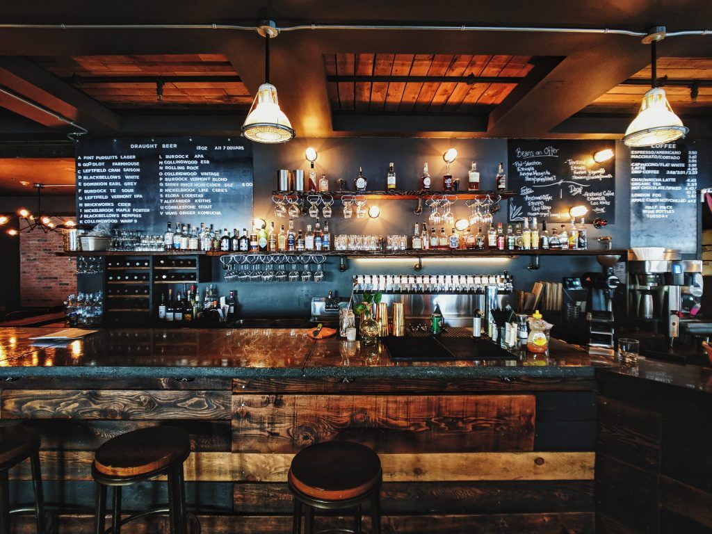 A bar with a lot of bottles on it and stools