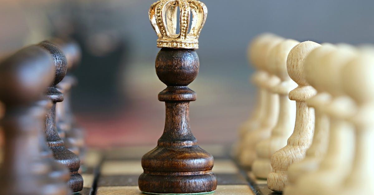 A close up of a wooden chess piece with a crown on top of it on a chess board.