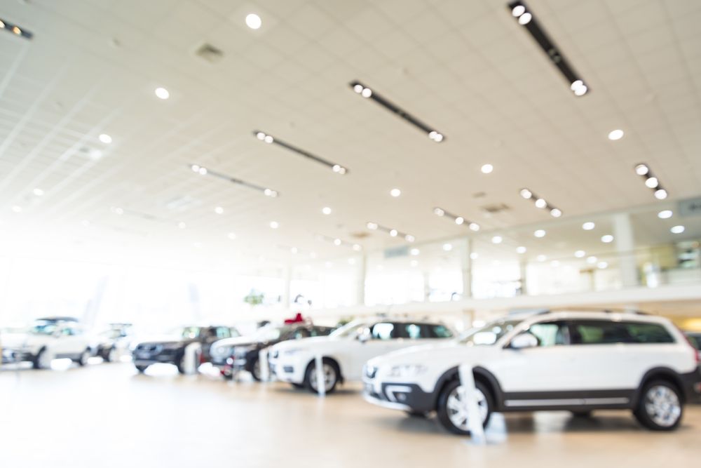 A row of cars are lined up in a showroom.
