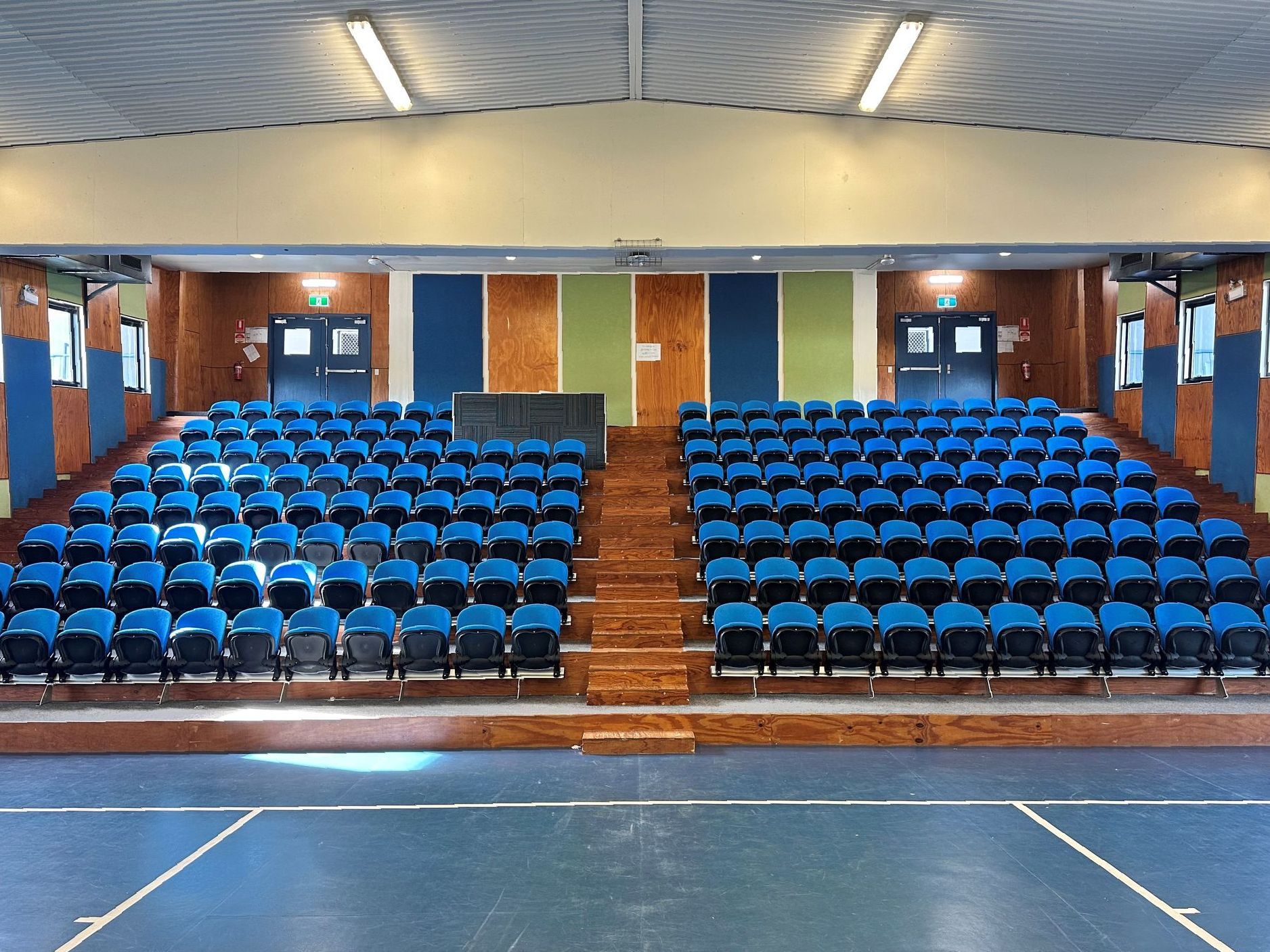 A large auditorium with blue seats and stairs