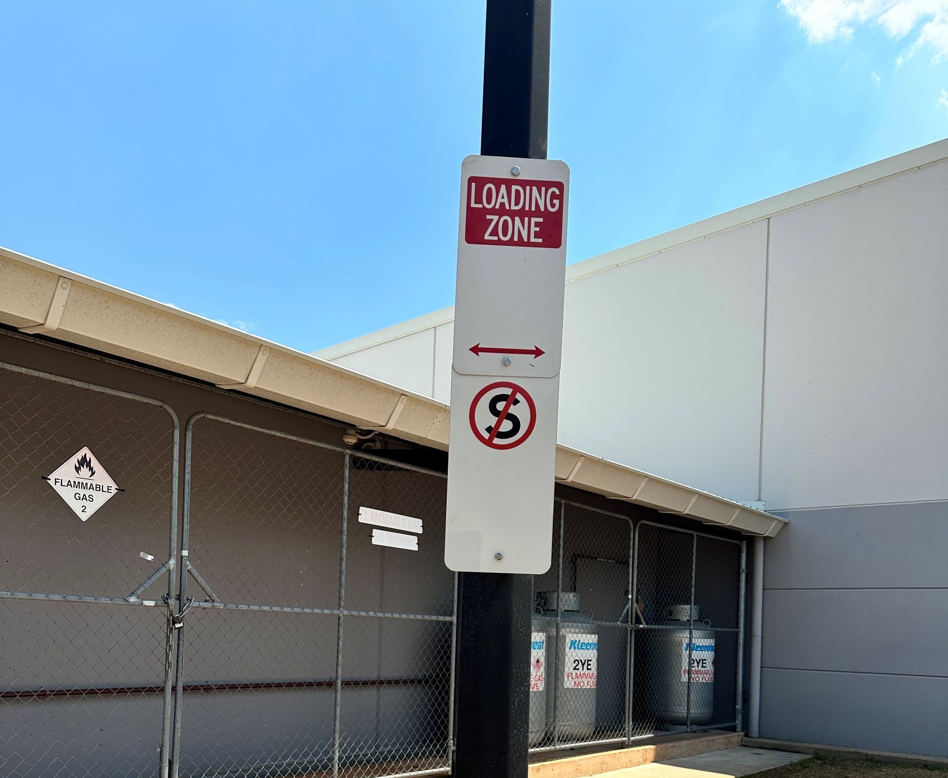 A sign on a pole that says loading zone