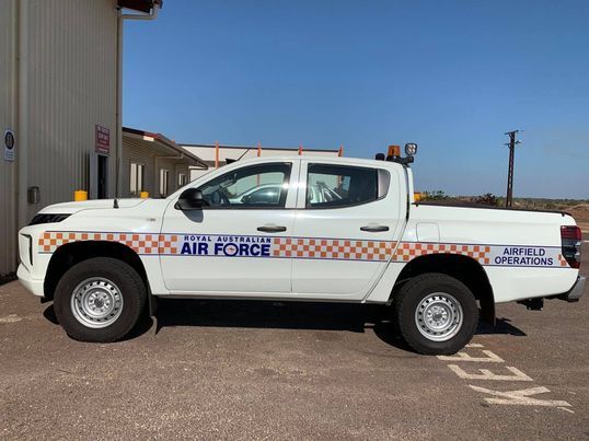 A white truck with air force written on the side is parked in a parking lot.