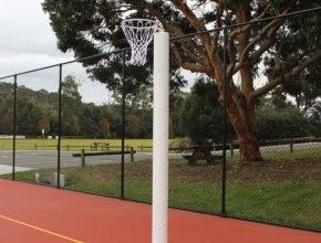 A basketball net is hanging from a pole on a court.