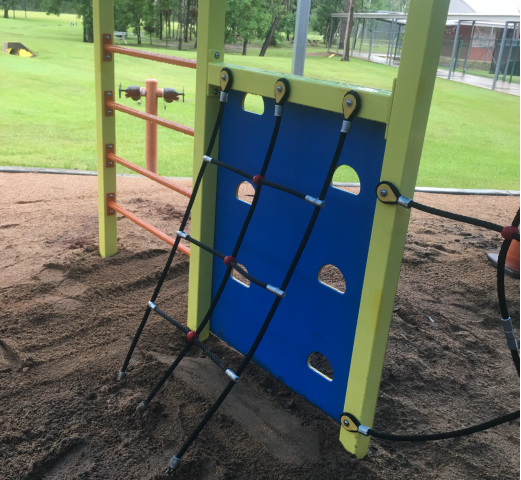 A playground with a blue wall and ropes