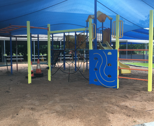 A playground with a blue wall that says r on it