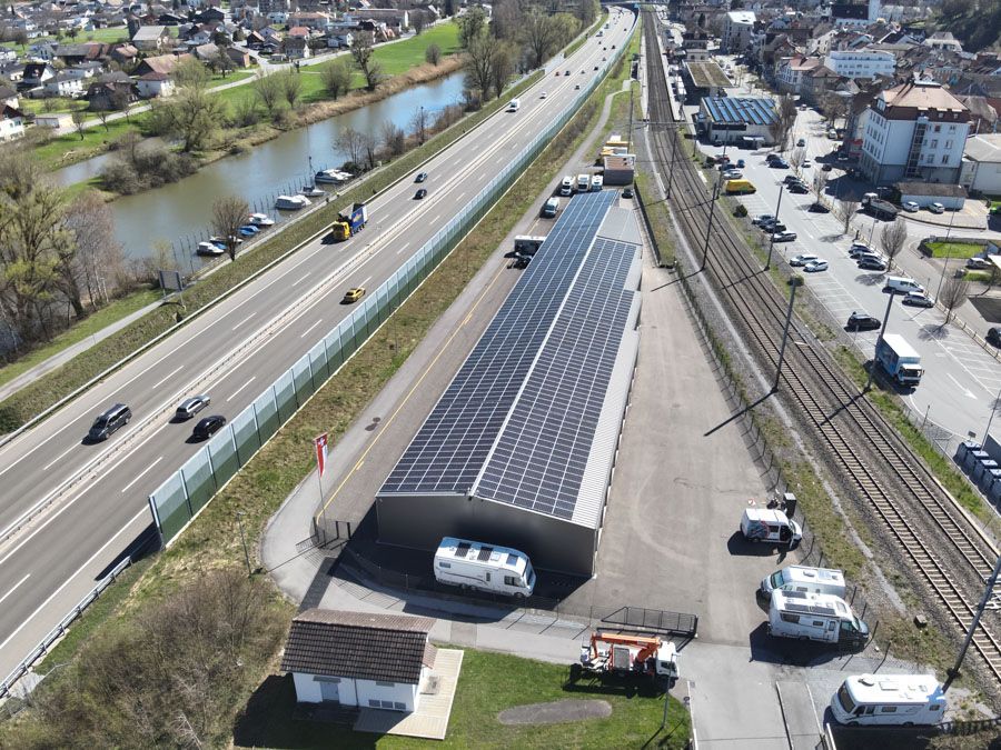 Drohnenaufnahme eines Industriegebäudes neben Bahngleisen