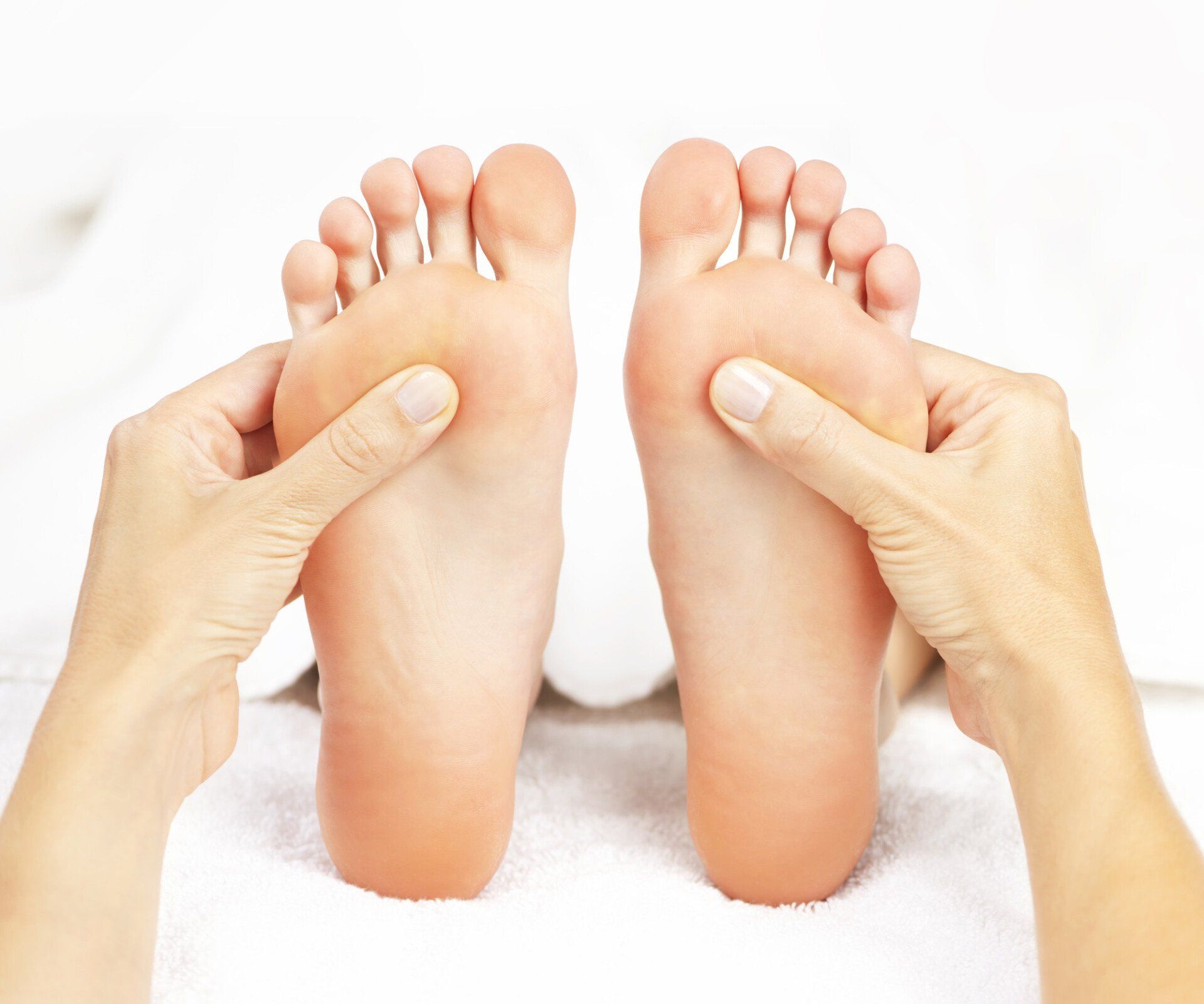 Close up of therapist's hands massaging a foot