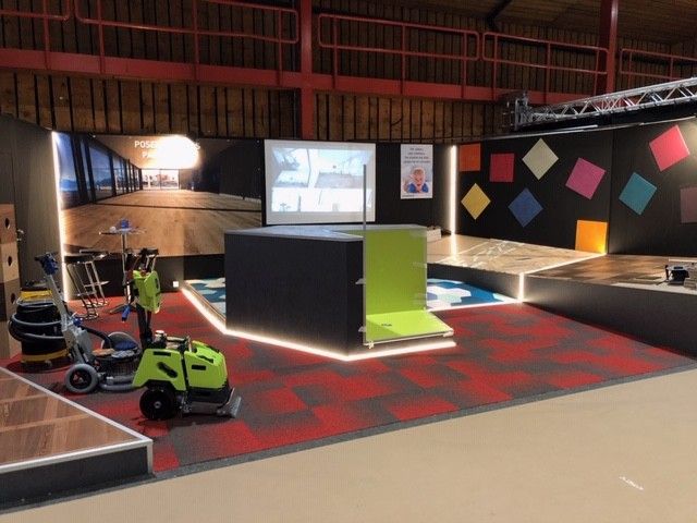 Une tondeuse à gazon verte est garée dans une pièce