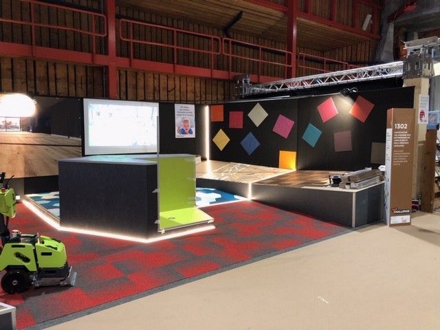 Une tondeuse à gazon verte est garée dans une pièce