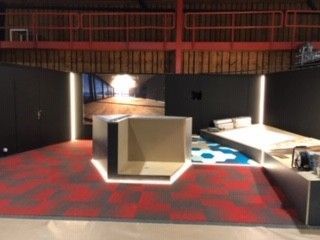 Une pièce avec un tapis rouge et un tableau sur le mur.