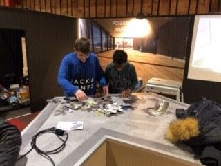 Deux jeunes hommes sont assis à une table et travaillent sur un projet.