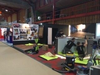 Un groupe de personnes travaille sur un stand lors d'une convention.