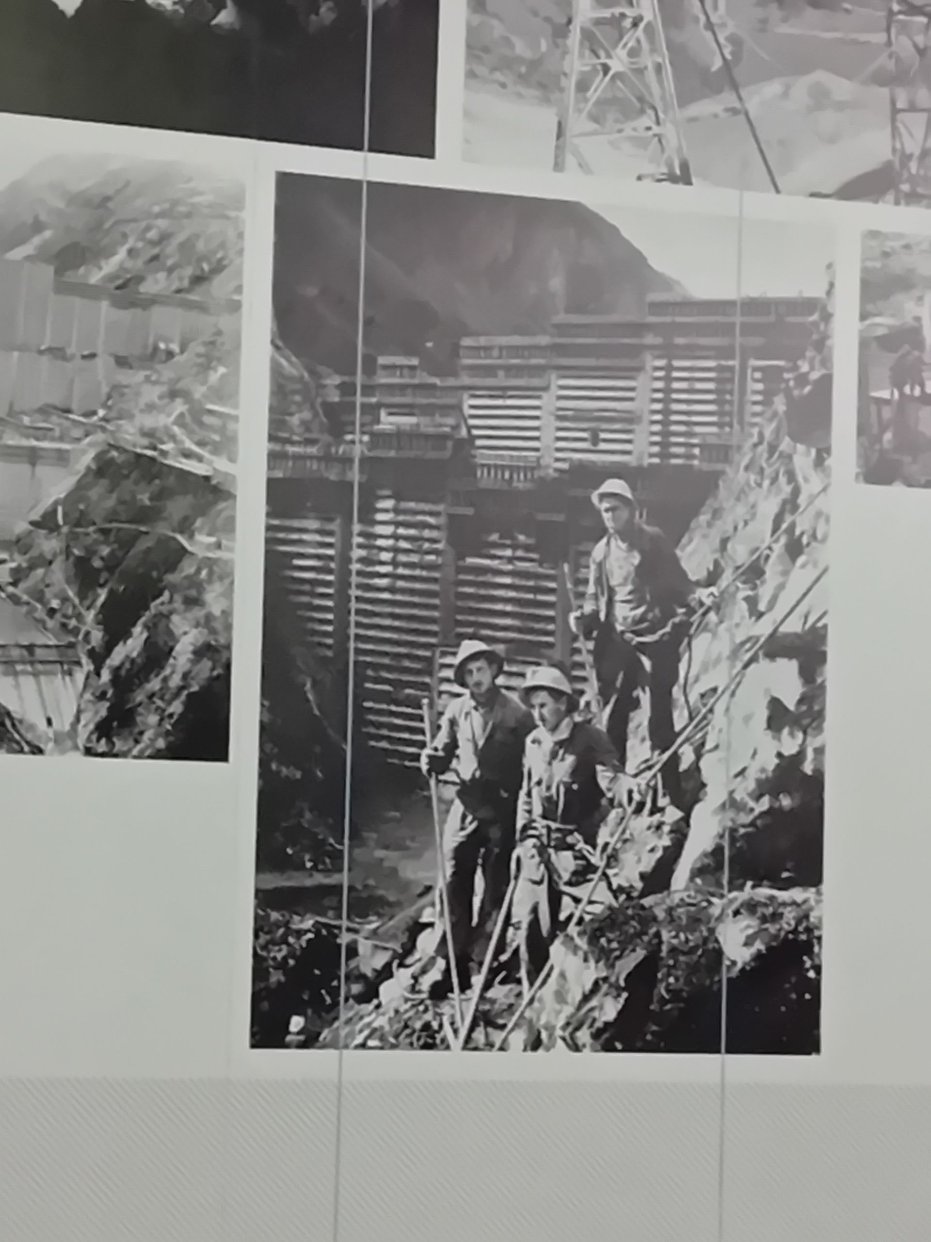 Une photo en noir et blanc de trois hommes debout sur un rocher