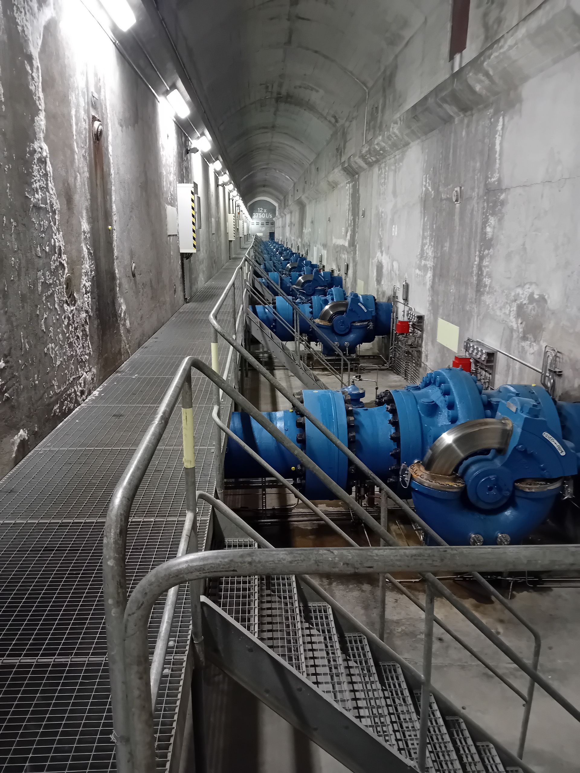 Une rangée de pompes bleues est alignée dans un tunnel