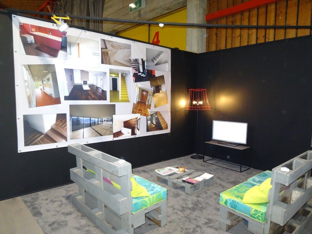 Un salon avec deux chaises et un grand mur avec des tableaux dessus