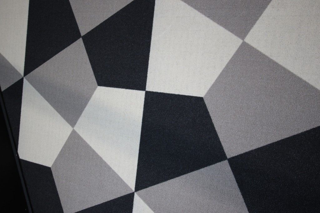 Un tapis noir et blanc avec un motif géométrique dessus