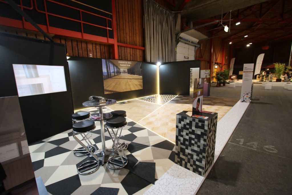 Une pièce avec un sol en damier et une télévision au mur