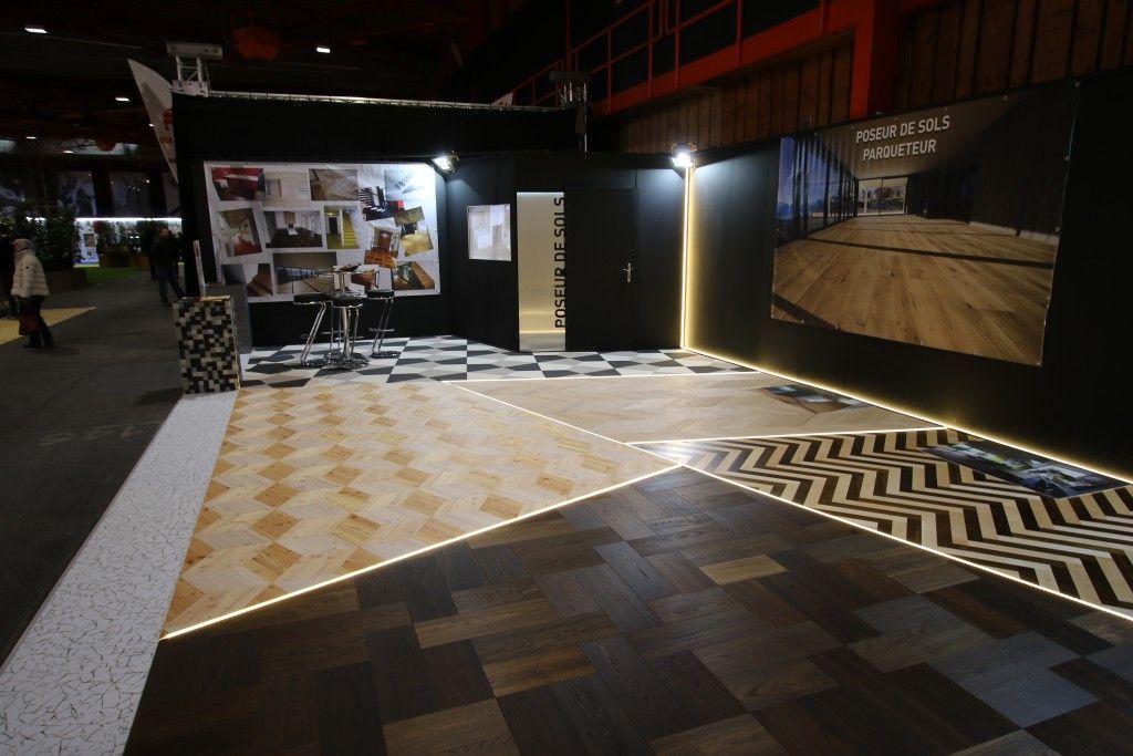 Une pièce avec un sol en damier et un mur avec des images dessus