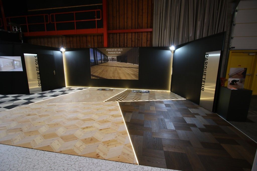 Une pièce avec deux types de sols différents et un tableau sur le mur