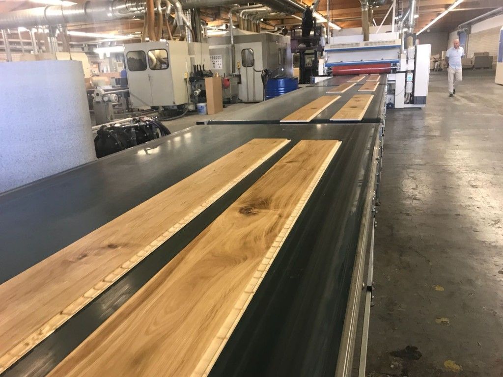 Un tapis roulant rempli de planches de bois dans une usine