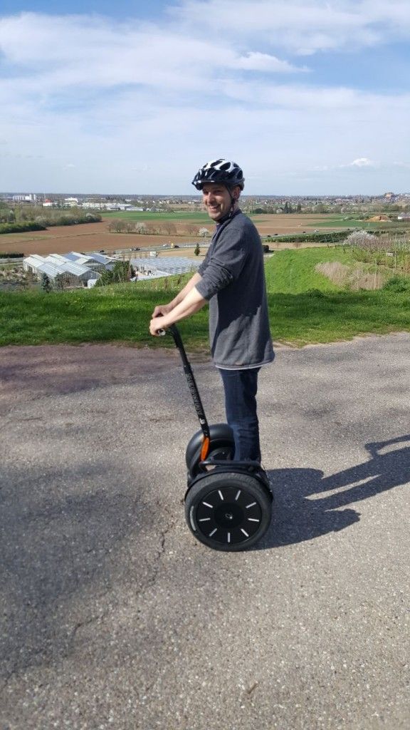 Un homme conduit un segway sur une route.