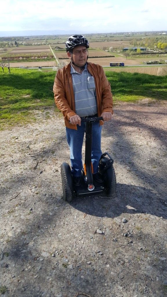 Un homme conduit un segway sur un chemin de terre.