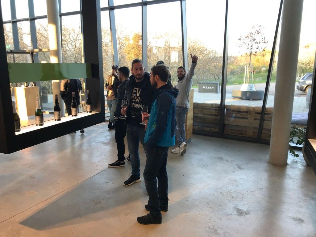 Un groupe d'hommes se tient devant une grande fenêtre.