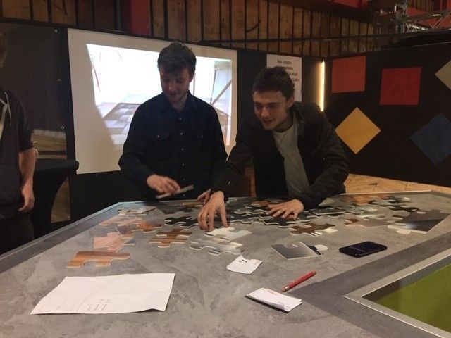 Deux hommes travaillent sur un puzzle sur une table