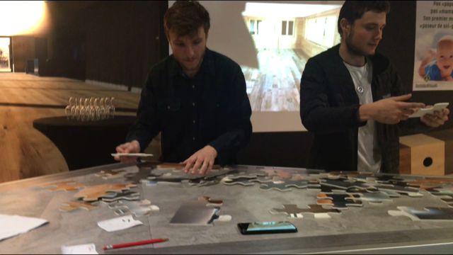 Deux hommes sont assis à une table avec un puzzle dessus