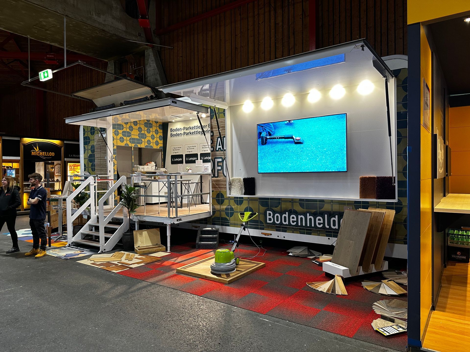 Un homme se tient devant une caravane avec une télévision sur le mur.